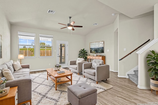 living room featuring ceiling fan, light hardwood / wood-style flooring, and vaulted ceiling