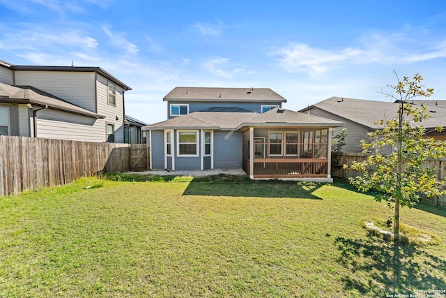 back of property featuring a lawn and a sunroom