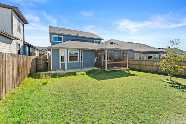 rear view of house featuring a lawn and a sunroom