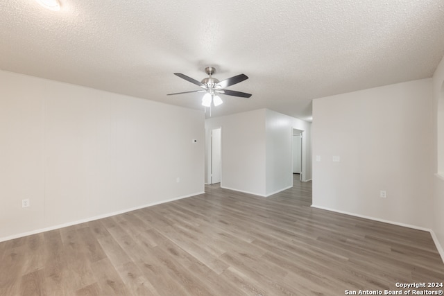 unfurnished room with hardwood / wood-style flooring, ceiling fan, and a textured ceiling