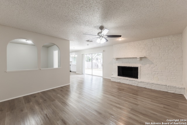 unfurnished living room with a fireplace, a textured ceiling, dark hardwood / wood-style floors, and ceiling fan