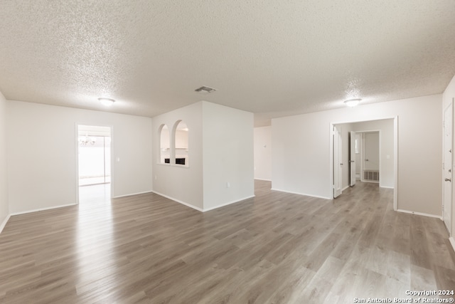 unfurnished room with a textured ceiling and hardwood / wood-style flooring