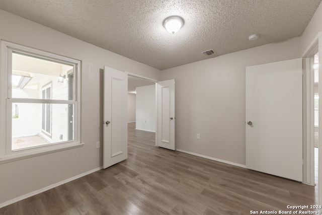 unfurnished bedroom featuring hardwood / wood-style flooring and a textured ceiling