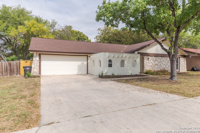 ranch-style home with a garage and a front lawn