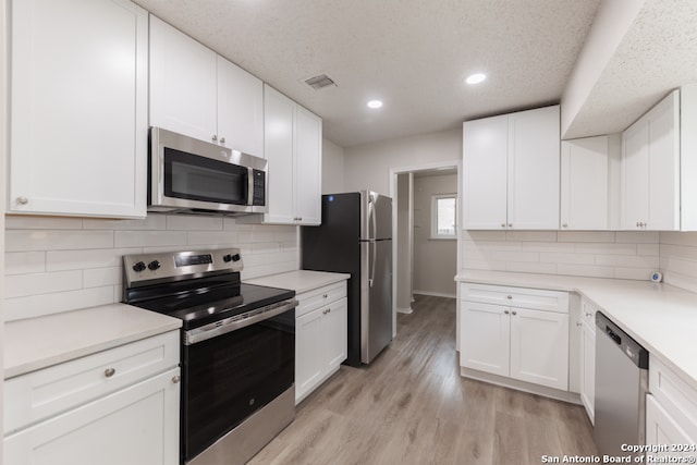 kitchen featuring white cabinets, light hardwood / wood-style floors, and appliances with stainless steel finishes