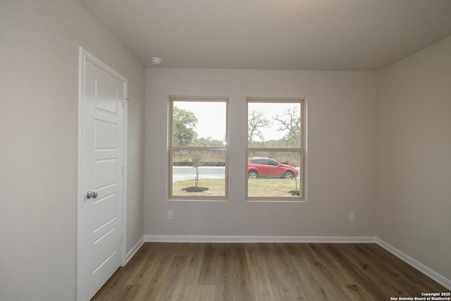 empty room with baseboards and wood finished floors