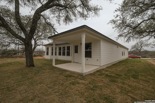 rear view of property with a patio and a yard