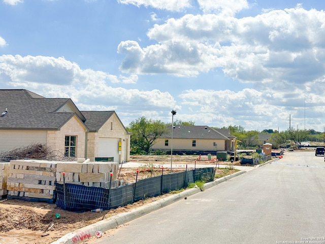 view of front facade with a garage, stone siding, and fence