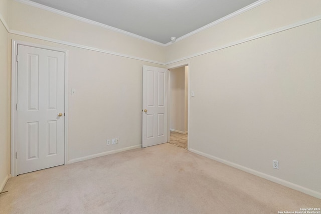 unfurnished bedroom with light carpet and crown molding