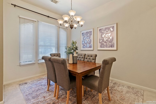 dining room with light colored carpet and a notable chandelier