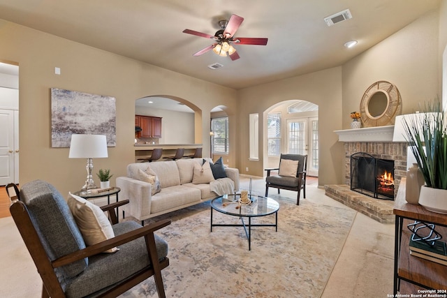 living room featuring ceiling fan and a brick fireplace