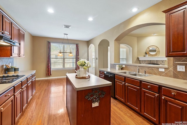 kitchen with dishwasher, sink, light hardwood / wood-style flooring, decorative light fixtures, and a kitchen island