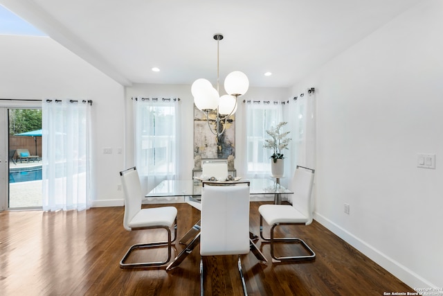 dining space with plenty of natural light, dark hardwood / wood-style floors, and an inviting chandelier