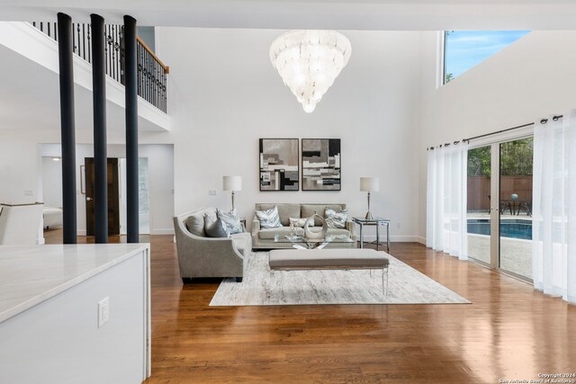 living room with a chandelier, hardwood / wood-style floors, and a high ceiling