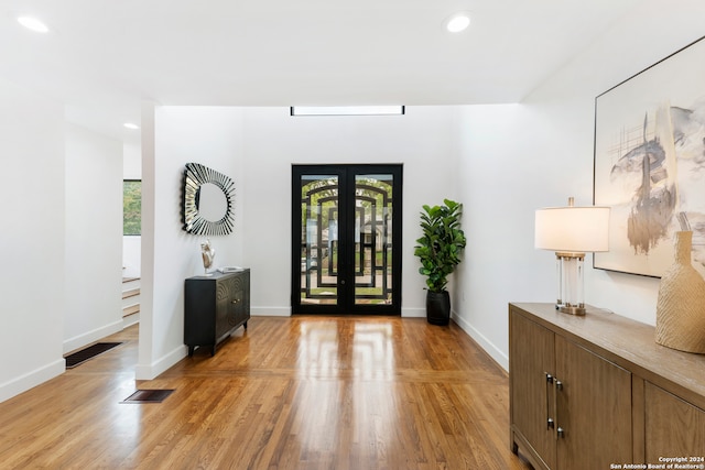 foyer entrance featuring light hardwood / wood-style flooring and french doors