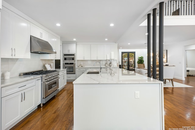 kitchen featuring stainless steel appliances, white cabinetry, a kitchen island with sink, and dark hardwood / wood-style floors