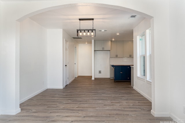 corridor with hardwood / wood-style floors and a textured ceiling