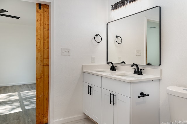 bathroom with ceiling fan, toilet, vanity, and hardwood / wood-style flooring