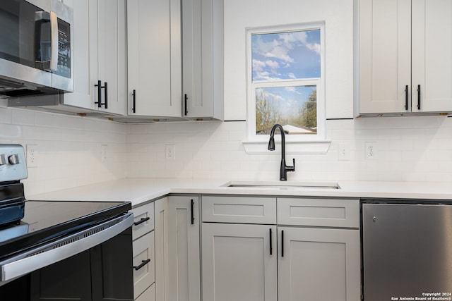 kitchen featuring white cabinetry, decorative backsplash, sink, and appliances with stainless steel finishes