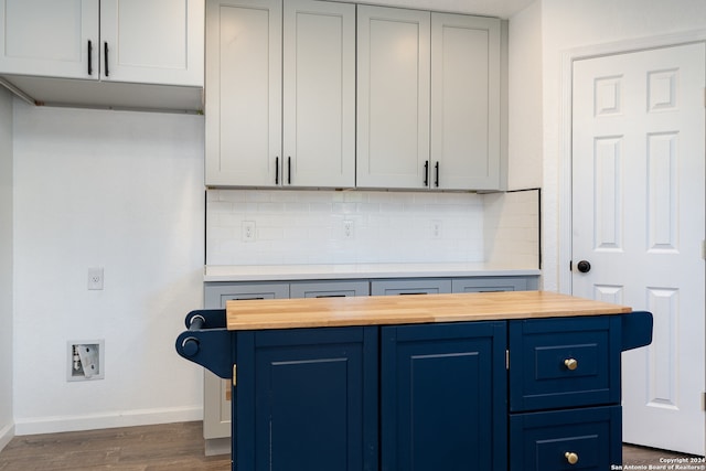 interior space featuring backsplash, blue cabinetry, wooden counters, and dark hardwood / wood-style floors