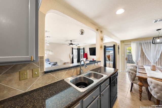 kitchen featuring pendant lighting, dishwasher, sink, decorative backsplash, and gray cabinets