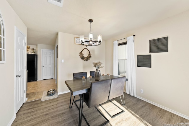 dining area with a chandelier and dark wood-type flooring