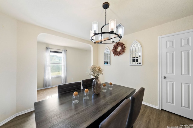 dining room with dark hardwood / wood-style floors and a notable chandelier