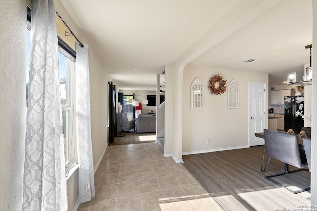 entryway with light tile patterned floors, a chandelier, and baseboards