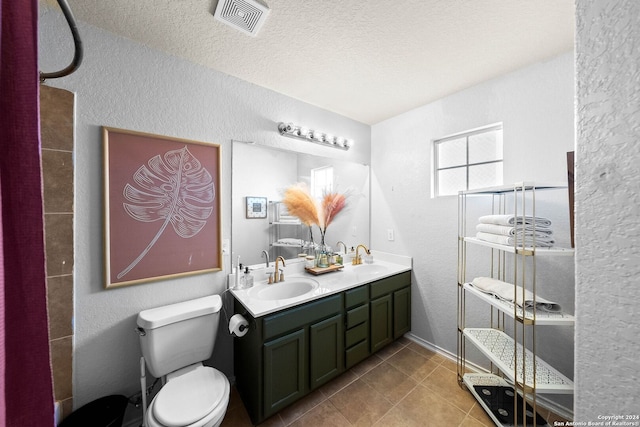 bathroom featuring vanity, a textured ceiling, toilet, and tile patterned flooring