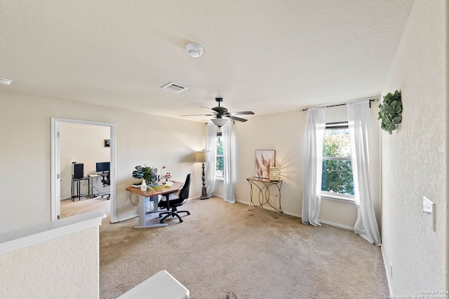 office featuring light carpet, a textured ceiling, and ceiling fan