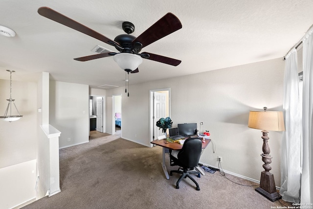 carpeted office featuring ceiling fan and a textured ceiling