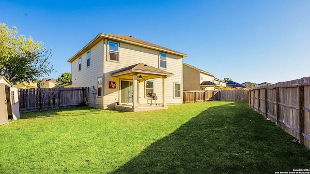 back of house with a lawn and a patio area