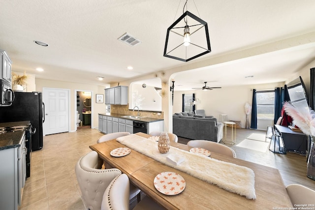 tiled dining area featuring a textured ceiling, ceiling fan, and sink