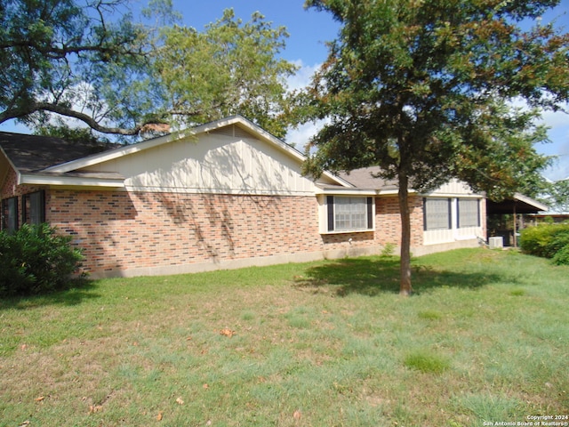 view of side of home featuring a lawn and a carport