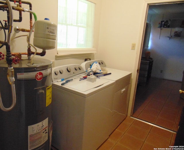 laundry room featuring water heater, washer and clothes dryer, and light tile patterned flooring