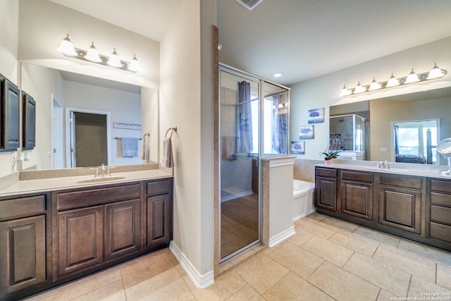 bathroom featuring tile patterned flooring, vanity, and plus walk in shower