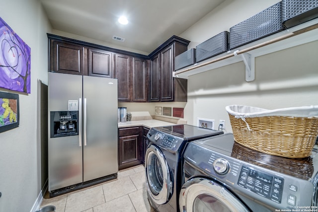 laundry room with separate washer and dryer, light tile patterned flooring, and cabinets