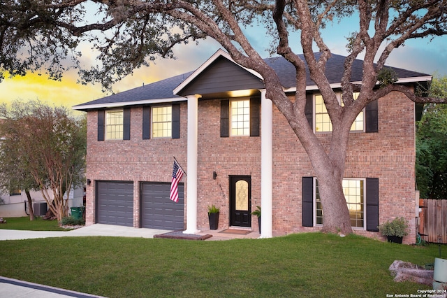 view of front of home with a yard and a garage