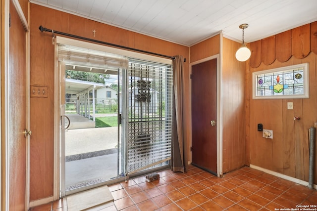 foyer with tile patterned flooring, wooden ceiling, and wooden walls