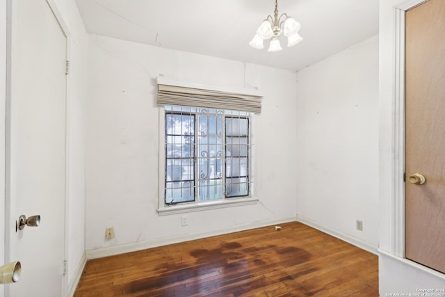 empty room featuring dark hardwood / wood-style floors and a chandelier