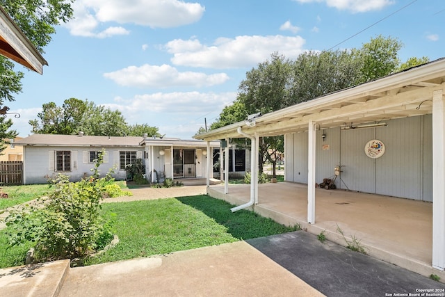 back of property featuring a lawn and a patio