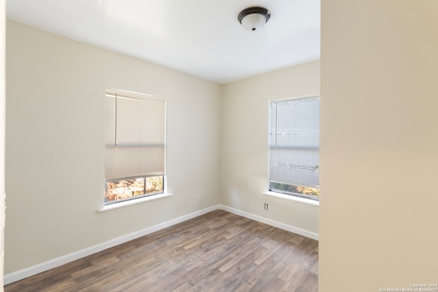 empty room with hardwood / wood-style flooring and a wealth of natural light