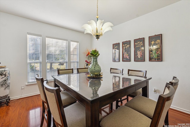 dining space with wood-type flooring and a notable chandelier