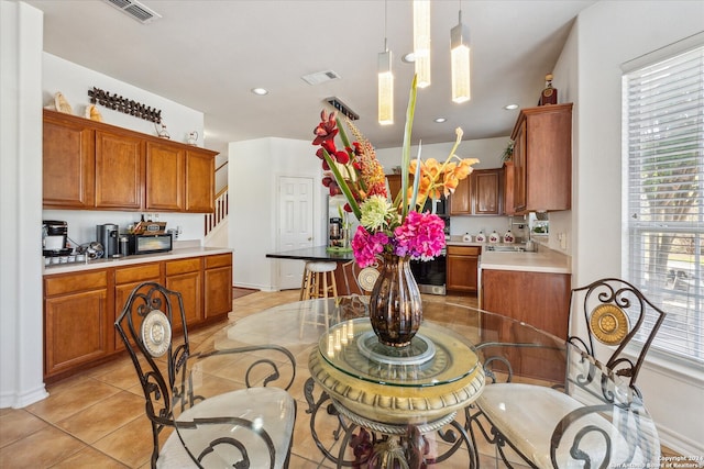 tiled dining space featuring an inviting chandelier and sink