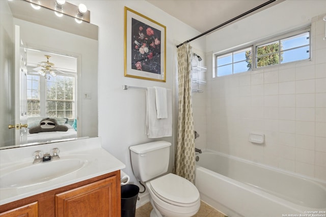 full bathroom featuring ceiling fan, tile patterned flooring, toilet, shower / bath combo with shower curtain, and vanity