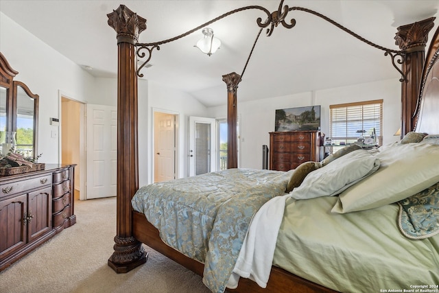 bedroom with light colored carpet and vaulted ceiling