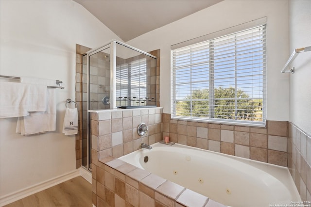 bathroom featuring hardwood / wood-style floors, shower with separate bathtub, and lofted ceiling