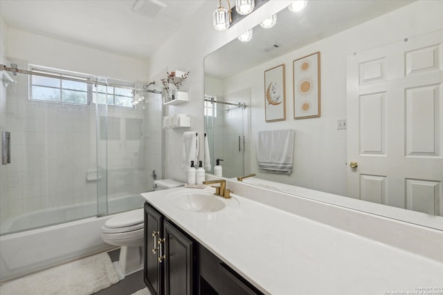 full bathroom featuring shower / bath combination with glass door, vanity, and toilet