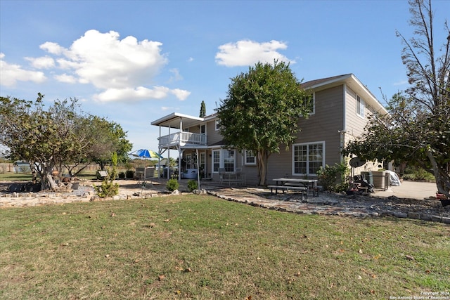 back of house featuring a yard, a balcony, cooling unit, and a patio area