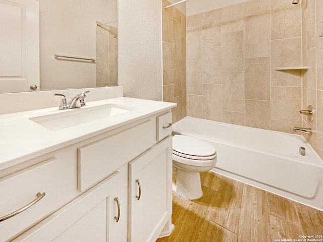 full bathroom featuring vanity, hardwood / wood-style flooring, toilet, and tiled shower / bath